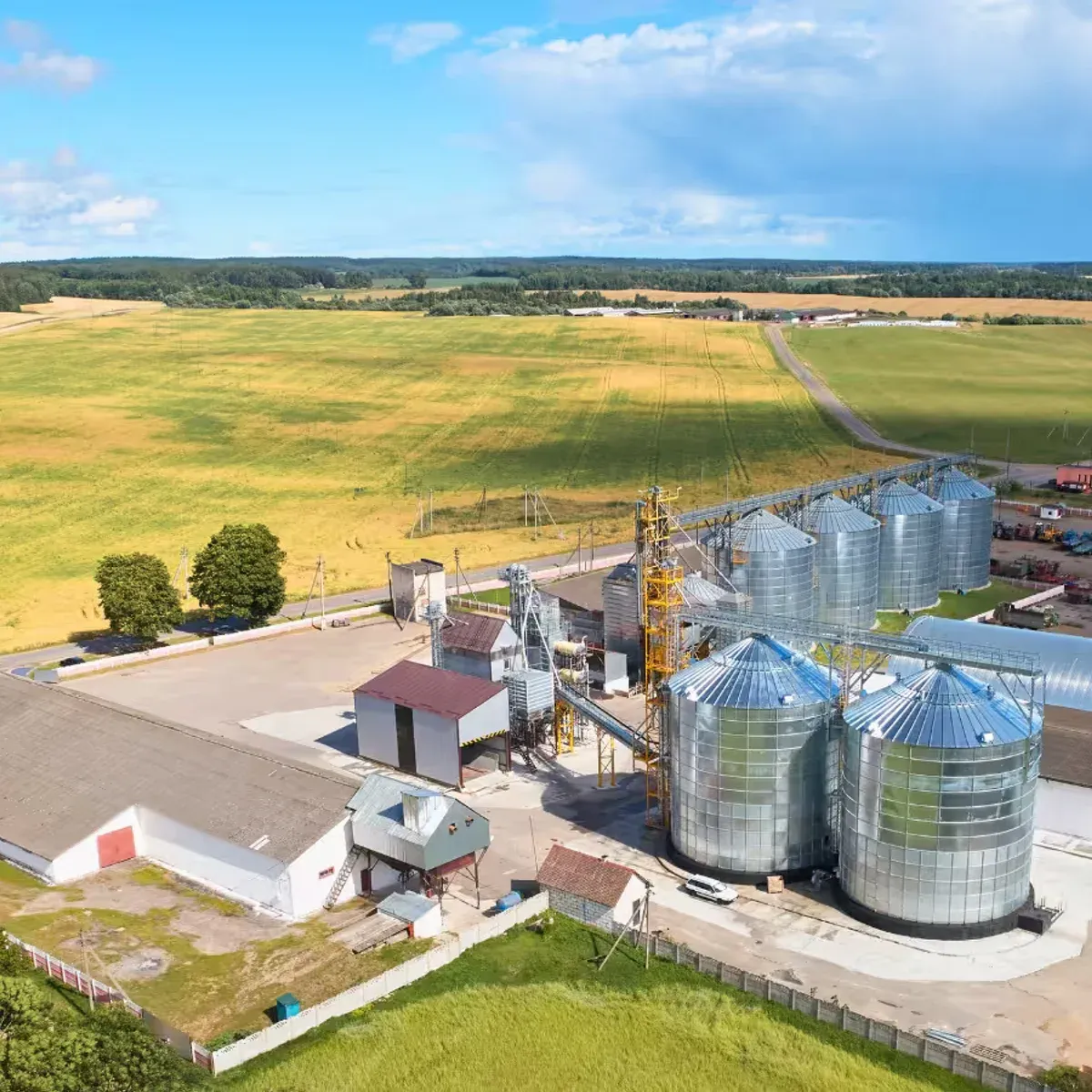 Vista aérea de uma fazenda com silos, armazém e lavoura