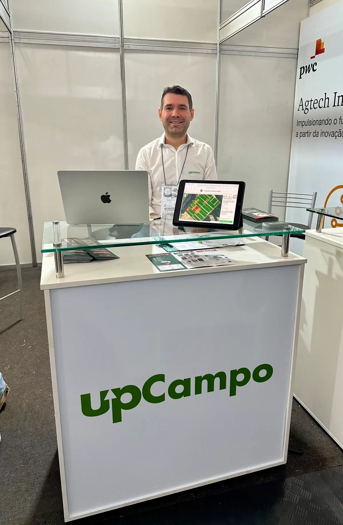 CEO de upCampo en el stand de Agrishow, con una tableta que muestra el dashboard de la plataforma