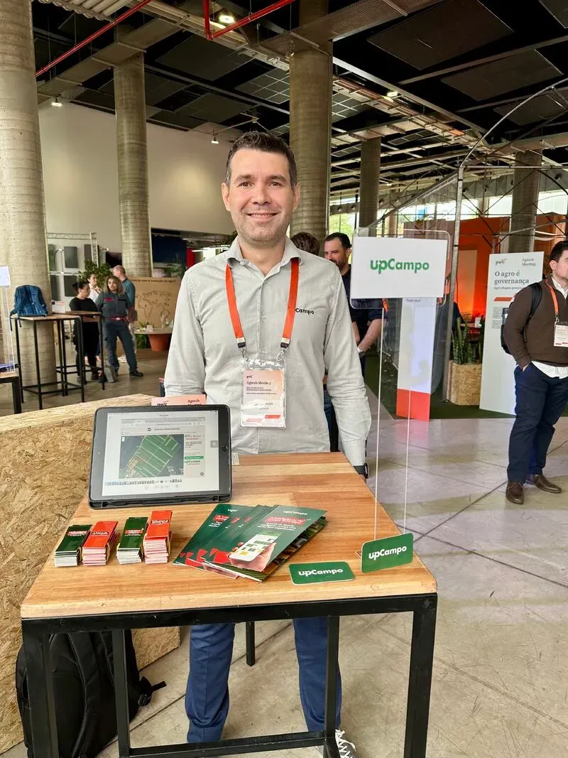 CEO de upCampo detrás de una mesa con una tableta, en una feria