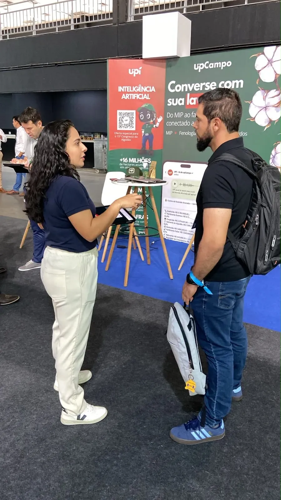 Conversa com um visitante em frente ao painel “Converse com sua lavoura”